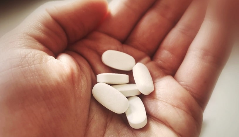 A hand holding pills.