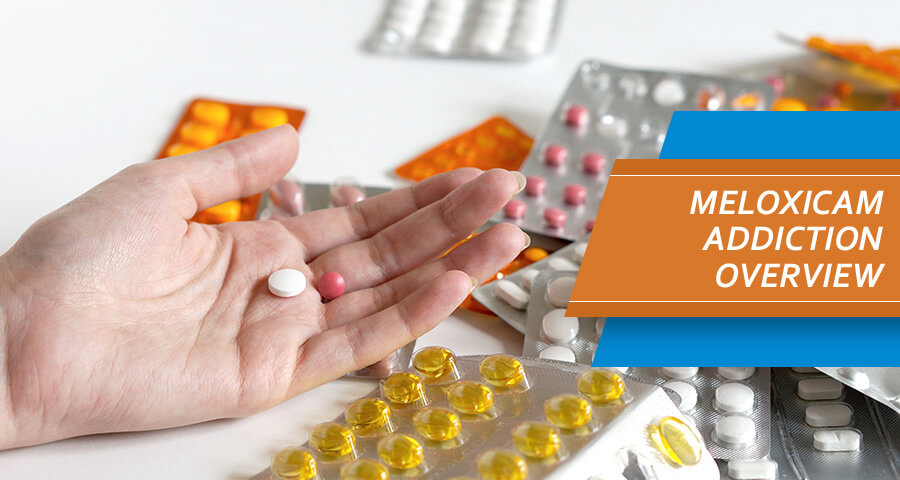 Female hand is holding pills of meloxicam and Mobic