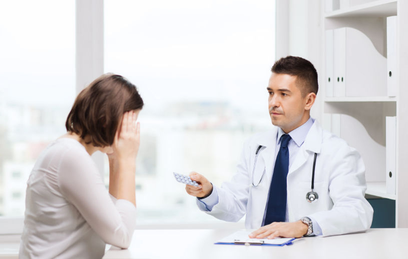 A doctor gives pills to a patient.