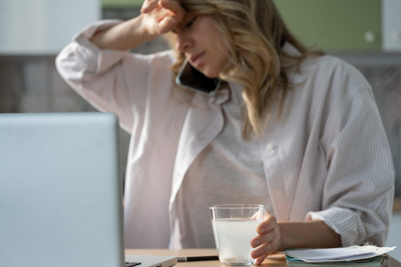 A woman with a glass of water and Vyvanse pills.