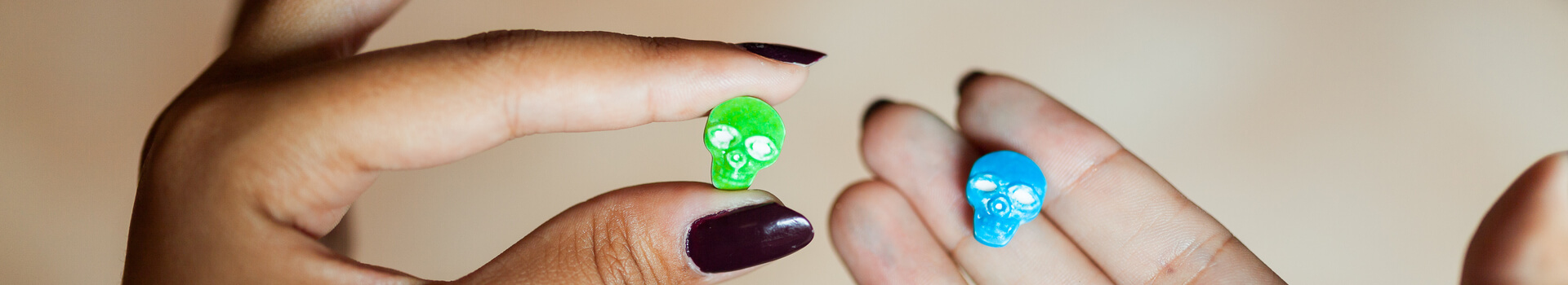 hands of woman holding skull-shaped pills
