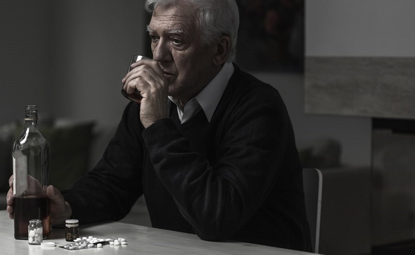 Depressed elderly alcoholic drinking alone.