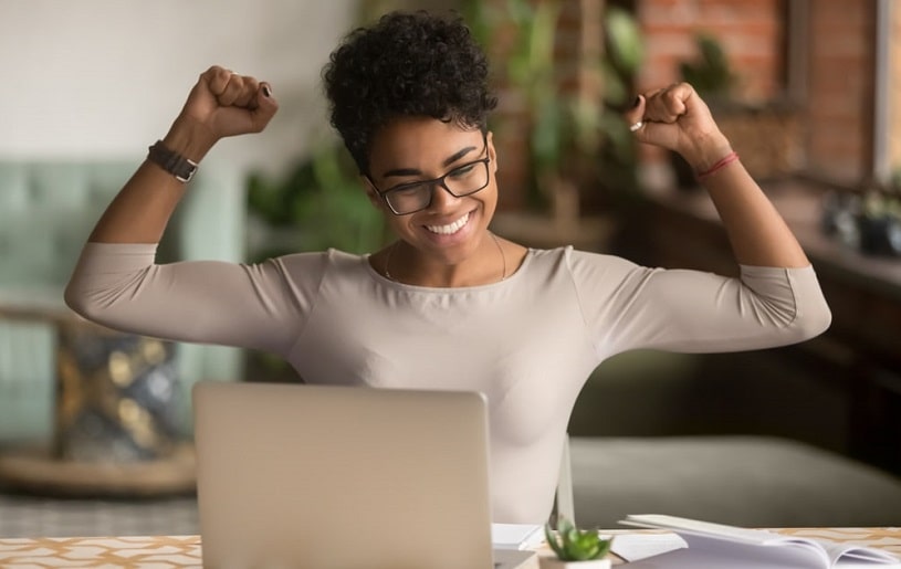 Excited woman smiling, working on the laptop.