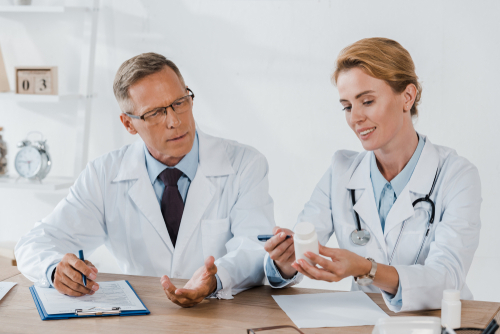 doctor looking at bottle of pills