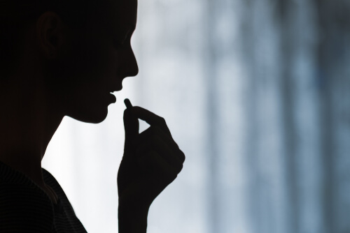 young woman taking prescription pill.