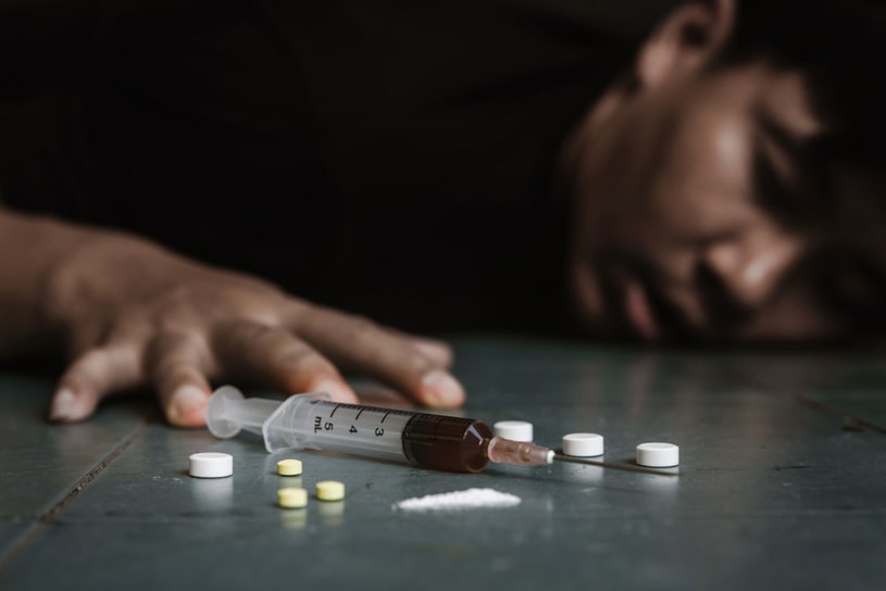 A young guy is lying on the floor after a drug overdose.