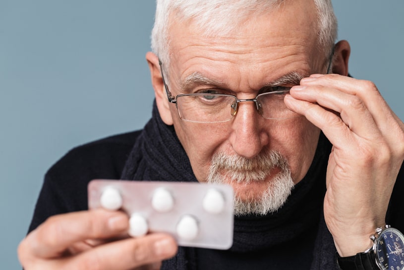 Senior man looking at his pills.