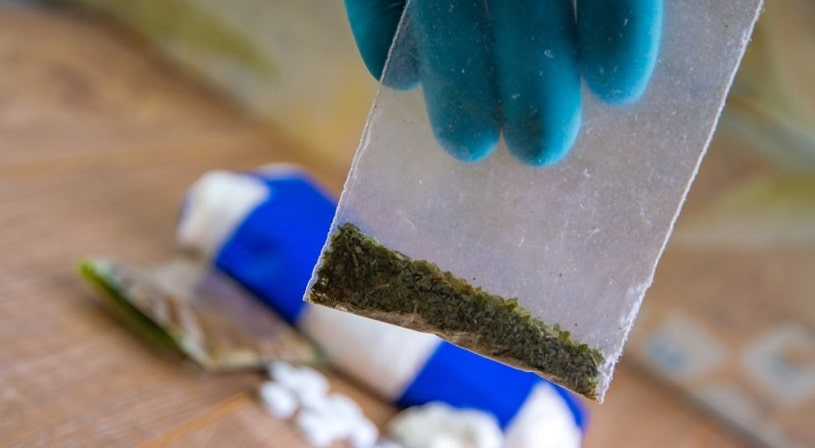 Lab assistant holding a bag of spice drug.