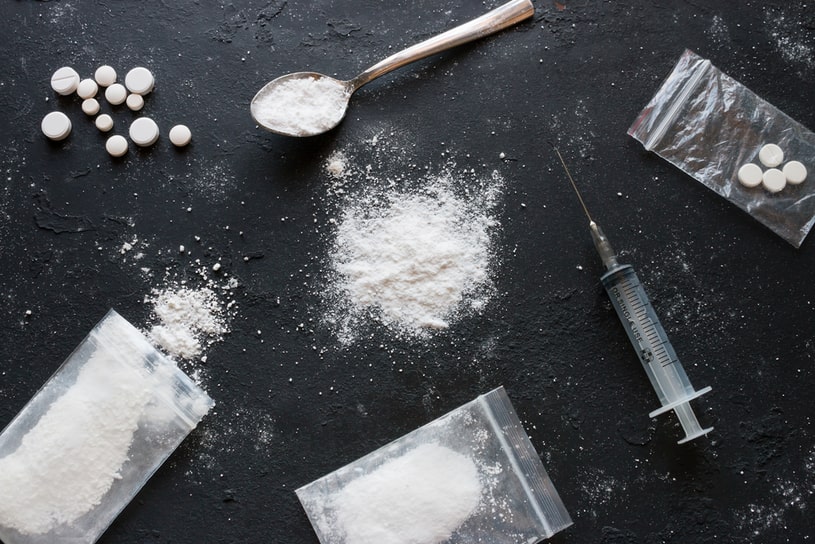 Different forms of drugs lie on a black background.