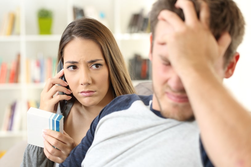A guy with a headache sits, and a girl behind him.