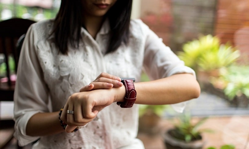 Depressed woman looking at her smart watch.