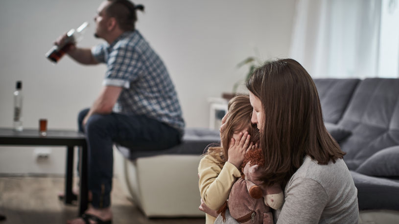 A woman is calming her daughter because her can't stop drinking alcohol.
