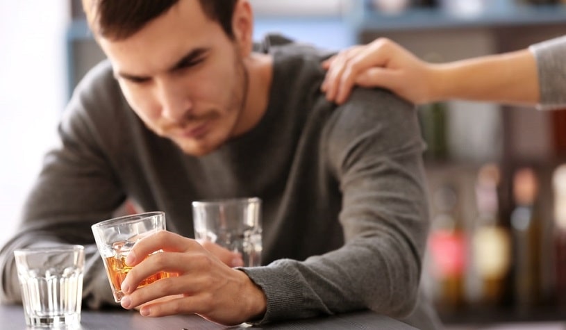 Depressed man drinking the third glass.