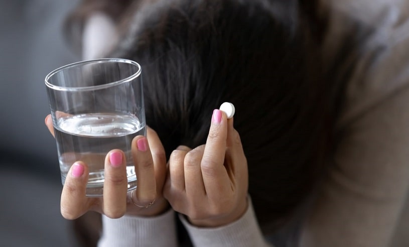 Sad depressed woman taking a pill.
