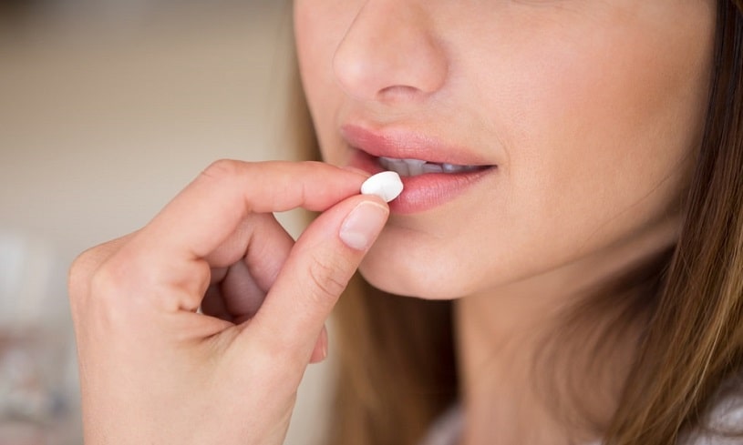 Woman taking Prozac pill.