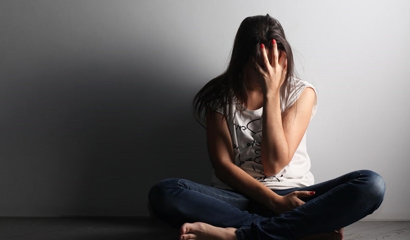 Girl sitting alone suffering from opioid withdrawal.