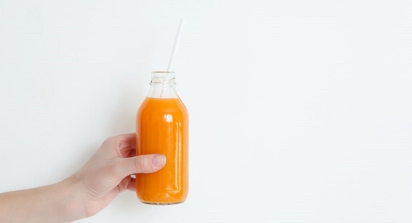 Girl holding a natural detox kit smoothie.